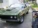 1970 Ford Ranchero - A green 1970 Ford Ranchero is parked in a driveway next to a lawnmower and a small wagon.