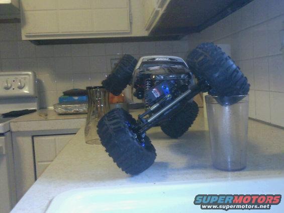 Remote control rock crawler truck on kitchen counter, one wheel in a glass