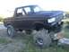 1987 Ford Bronco - This lifted Ford Bronco is shown off-roading with its front tires on rocks, revealing its suspension and matte black paint.