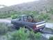 1987 Ford Bronco - A Ford Bronco navigates a muddy trail with two people inside.