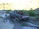 1987 Ford Bronco - This 1987 Ford Bronco navigates a challenging muddy path in a rural, hilly area.