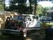 1988 Ford Bronco - A man works on a white Ford truck that has had its engine removed, parked outdoors.