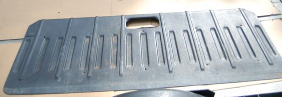 Gray plastic tailgate panel with vertical ridges and a central oval cutout