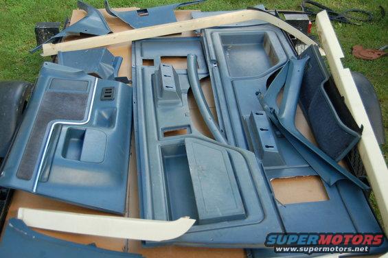 Blue interior door panels and trim pieces laid out on a surface
