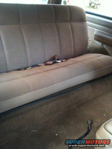 Rear bench seat with brown upholstery and seatbelt