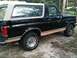 1989 Ford Bronco - Side view of a black 1989 Ford Bronco with tan trim and a removable hardtop.