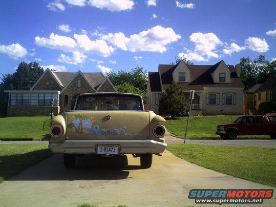 Rear view of a yellow 1972 Ford Ranchero with custom beach mural and license plate 1-81473