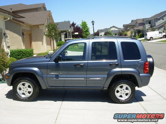 Gray 2002 Jeep Liberty SUV parked on a suburban street, side view
