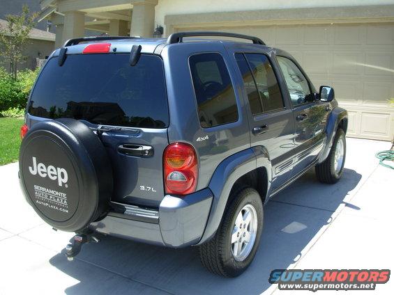 Gray 2002 Jeep Liberty with a rear-mounted spare tire and a tow hitch