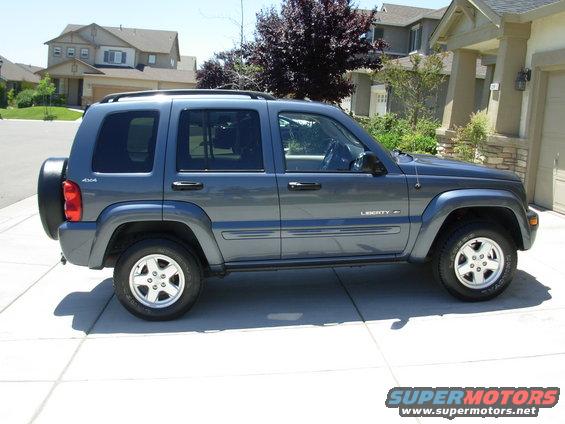 Gray 2002 Jeep Liberty side view with spare tire on rear door