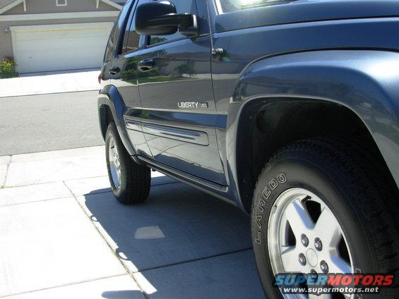 Side view of a dark blue Jeep Liberty parked on a driveway