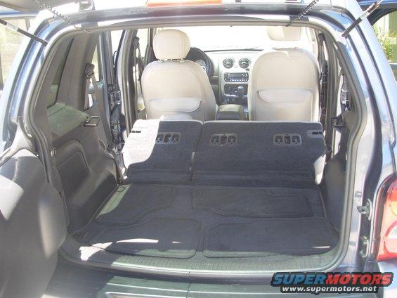Back of a 2002 Jeep Liberty with seats folded down, showing cargo area and front seats