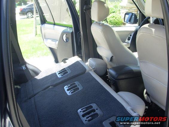 Interior view of folded rear seats and light-colored front seats