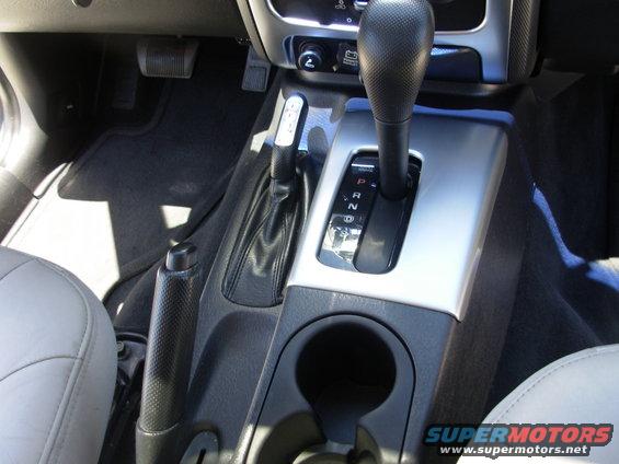 Center console of a 2002 Jeep Liberty showing automatic gear shifter, handbrake, and cup holder
