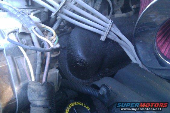 Engine bay with wires, hoses, and black fluid buildup