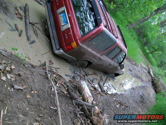 Red SUV stuck in mud, rear view showing license plate J6Y 554