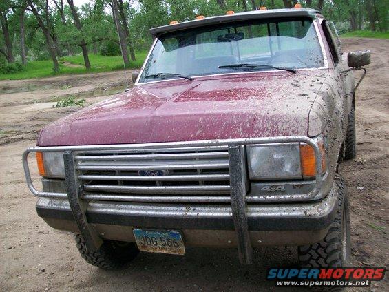 1988 Ford F-150 pickup truck with brush guard, covered in mud