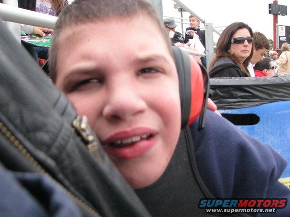 Boy wearing red and black headphones, looking towards the camera