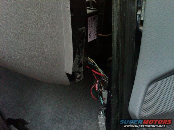 Close-up of exposed wiring harness and connectors inside a vehicle's dashboard area