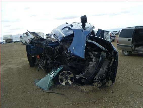 Front-end collision damage on a blue 2005 Dodge 3500 truck