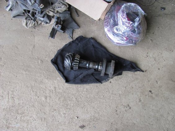 Differential gear and shaft assembly on black cloth, with other parts and a box in the background