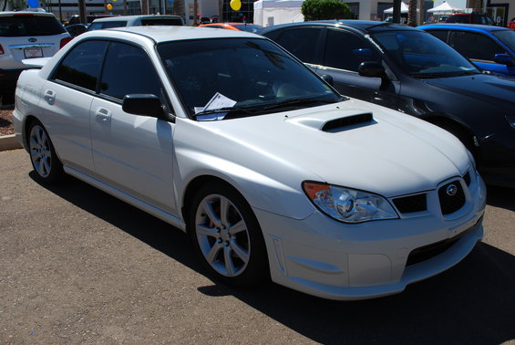 White Subaru Impreza sedan with hood scoop, parked outdoors