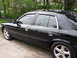 2003 Mercury Marauder - This black sedan, likely a 2003 Mercury Marauder, is seen from the side with tinted windows and chrome accents.