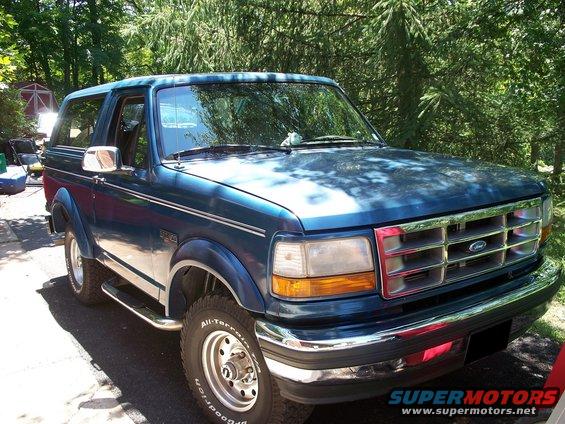 Blue 1995 Ford Bronco parked outdoors with trees in the background