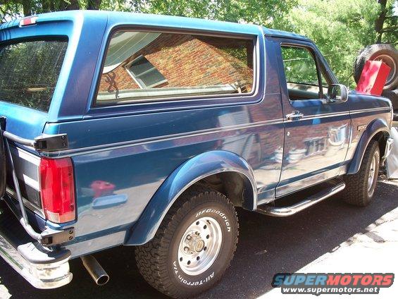 Blue SUV parked outside, side view. Has a spare tire carrier on the back