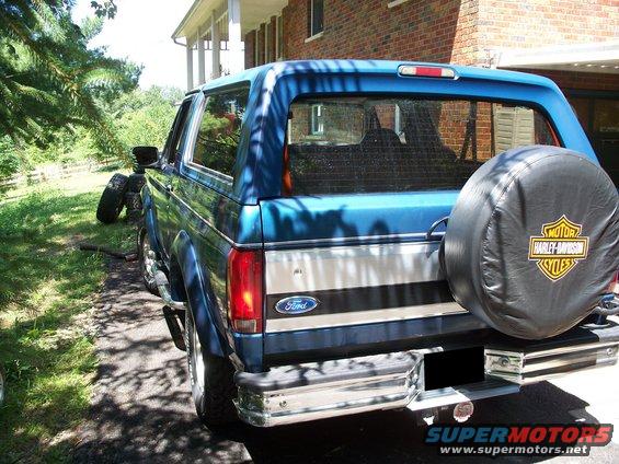 Rear view of a blue 1995 Ford Bronco with a Harley-Davidson spare tire cover