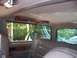 1995 Ford Bronco - The interior of a vehicle shows leather seats and a view of greenery through the windows.