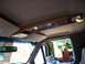 1995 Ford Bronco - The wood-trimmed overhead console and interior lighting of a 1995 Ford Bronco.