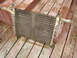 1989 Ford Bronco - A car radiator part is shown resting on weathered wooden planks.