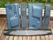 1989 Ford Bronco - Several blue interior door panels and a piece of trim are displayed on a weathered wooden surface outdoors.