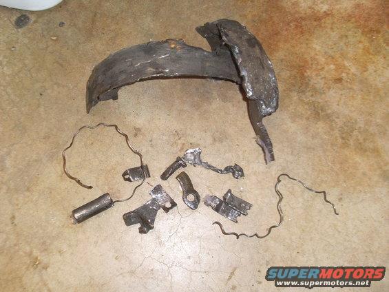 Damaged brake rotor and metal fragments on concrete floor