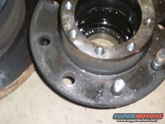 Close-up of a greasy wheel hub assembly with visible bearings