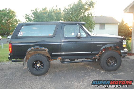 Black Ford Bronco SUV with rust on wheel wells and running boards, side view