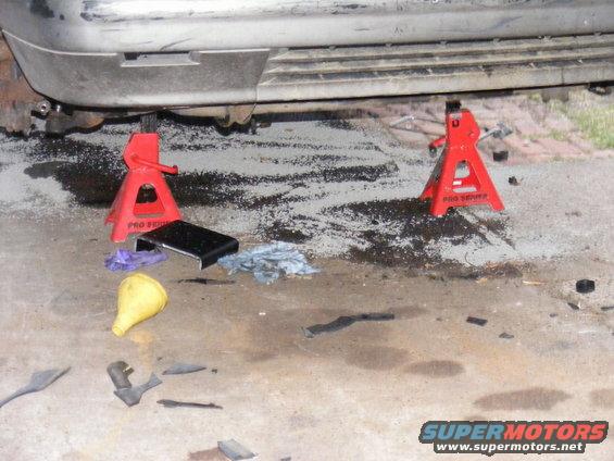 Vehicle side view, raised on jack stands with tools on the ground