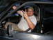 1989 Ford Escort - Man sits inside a car, giving a peace sign.