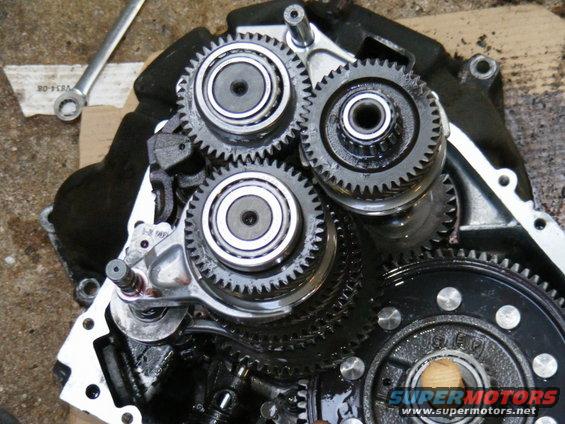 Close-up of internal gears and bearings within a mechanical assembly, with a wrench visible