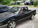 1989 Ford Escort - A black 1989 Ford Escort pickup truck is parked outside with a young boy in the driver's seat.