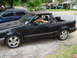 1989 Ford Escort - A young boy smiles from the driver's seat of a black 1989 Ford Escort pickup truck.
