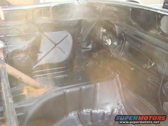 Black car interior floor with rust on a metal bar