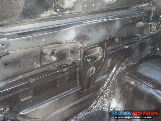 close-up of black painted metal structure inside a vehicle, possibly trunk or undercarriage area