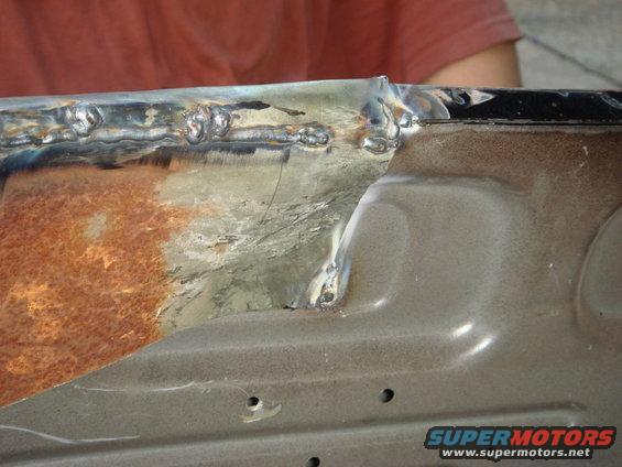 rusted metal panel with fresh welds and some surface rust