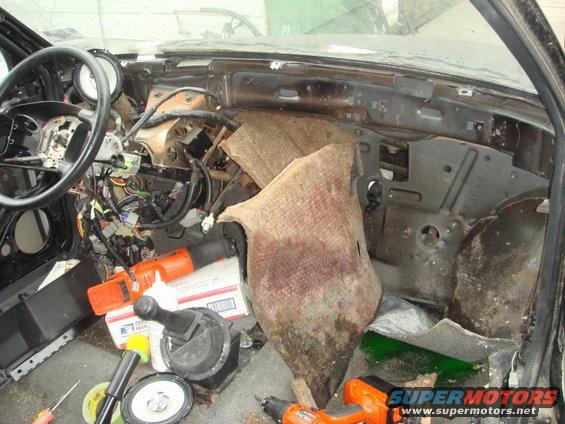Interior dashboard disassembly with exposed wires and tools
