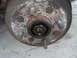 1989 Ford Escort - Close-up view of a rusted wheel hub assembly, showing the lug bolts and central nut.