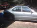 1994 Honda Accord - Side view of a silver 1994 Honda Accord sedan with a red pickup truck in the background.