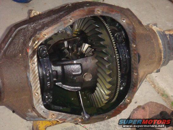 Open differential housing showing ring and pinion gears, with Supermotors.net logo at bottom right