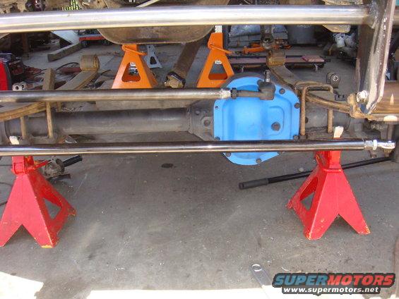 Vehicle axle assembly on jack stands, with a blue differential cover